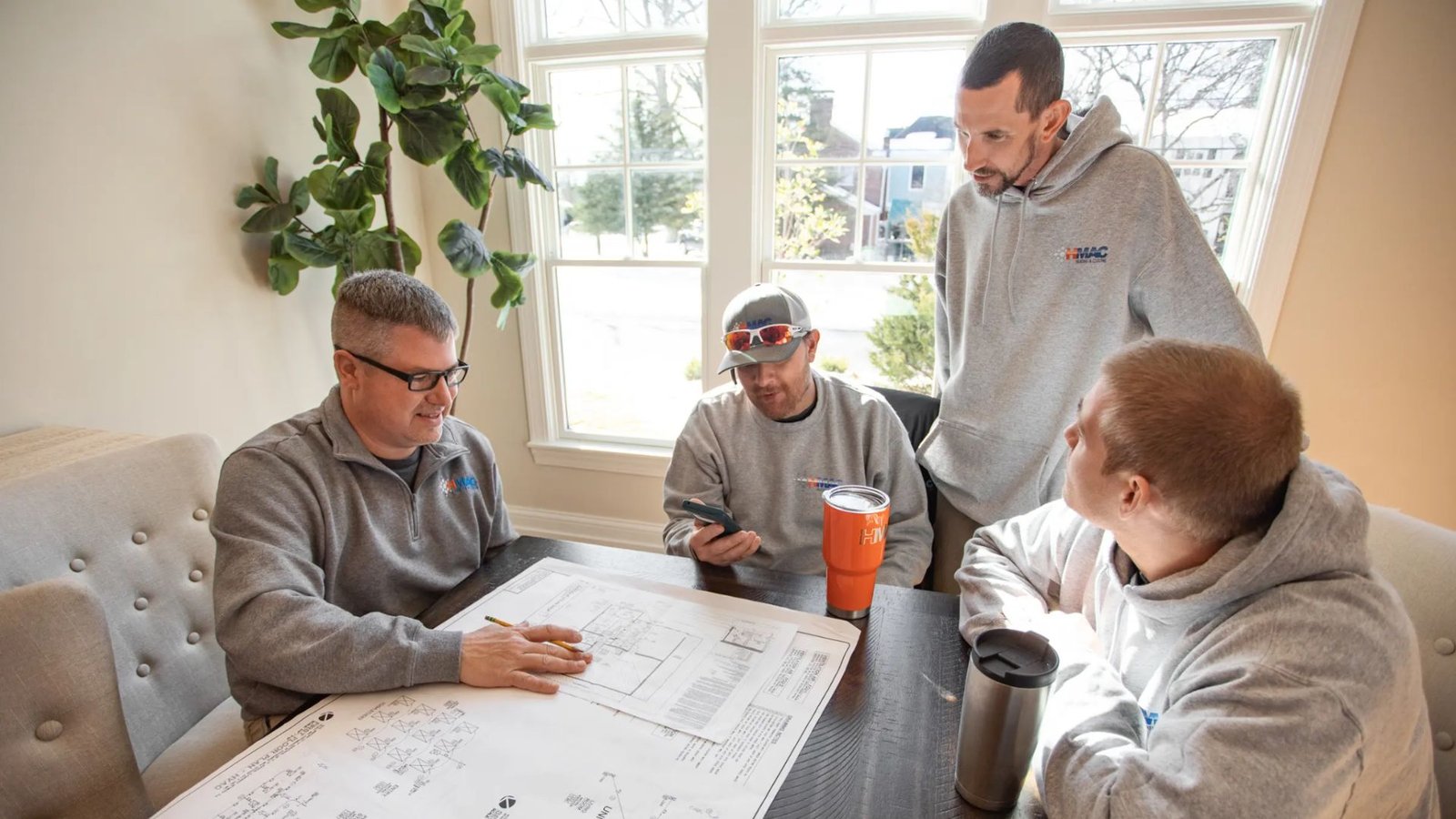 HVAC contractor reviewing geothermal system plans with homeowner