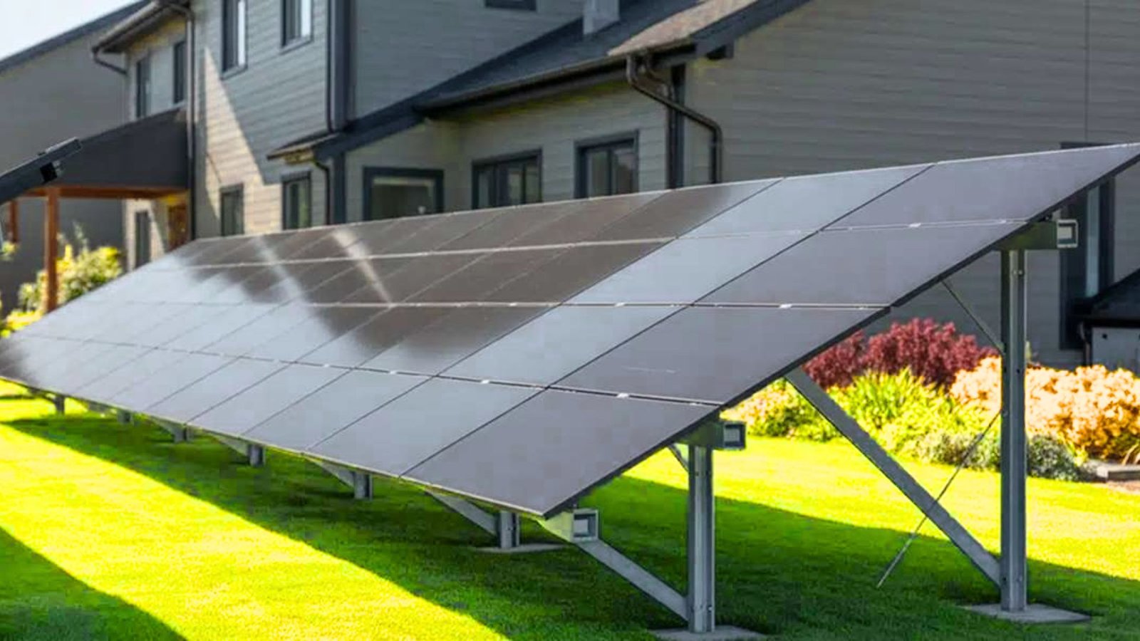 Ground-mounted solar panels installed in the yard of a mobile home, showcasing renewable energy use.