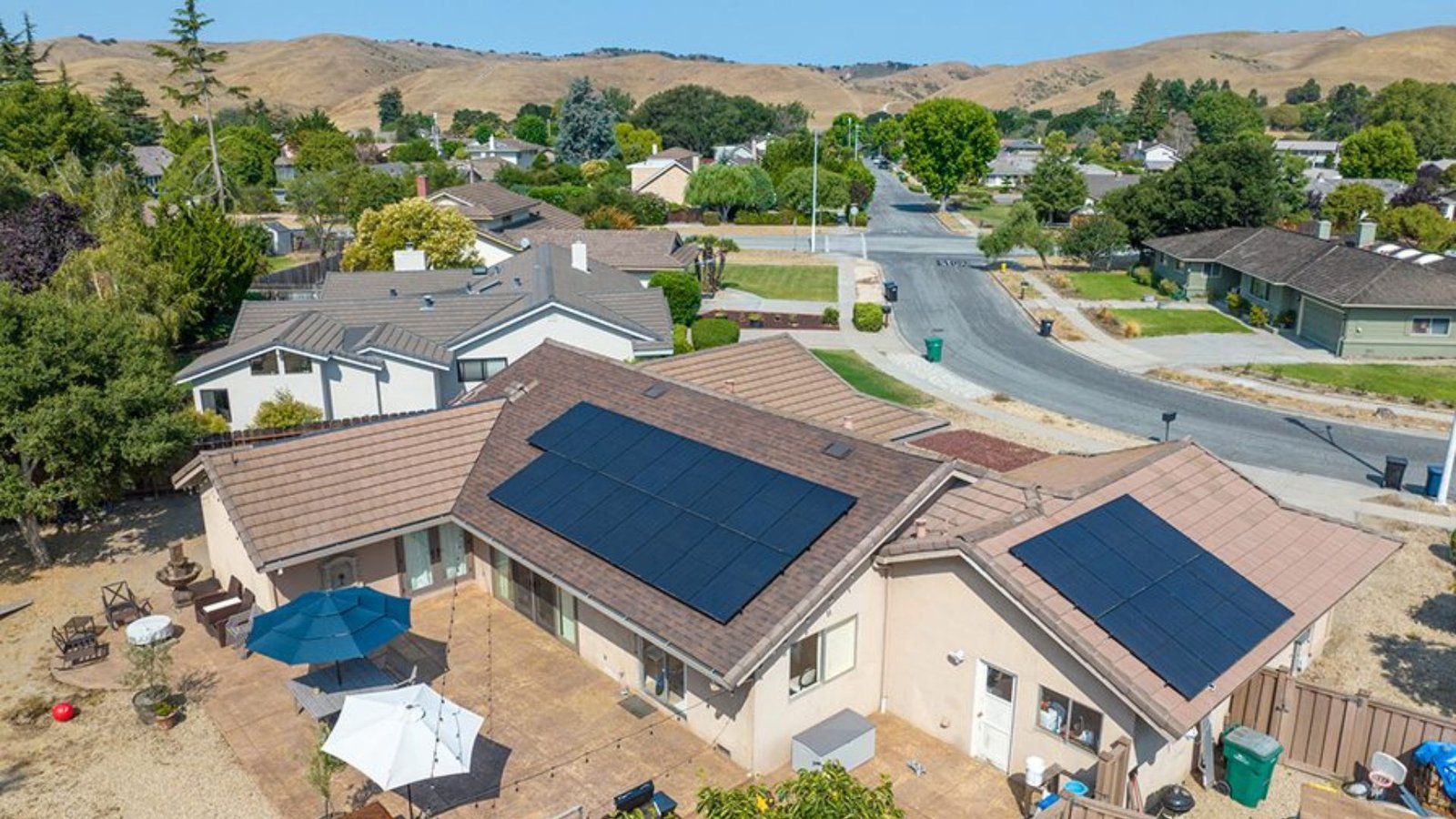 California suburban homes with rooftop solar panels under sunny skies, highlighting the growing role of solar energy in the housing market.